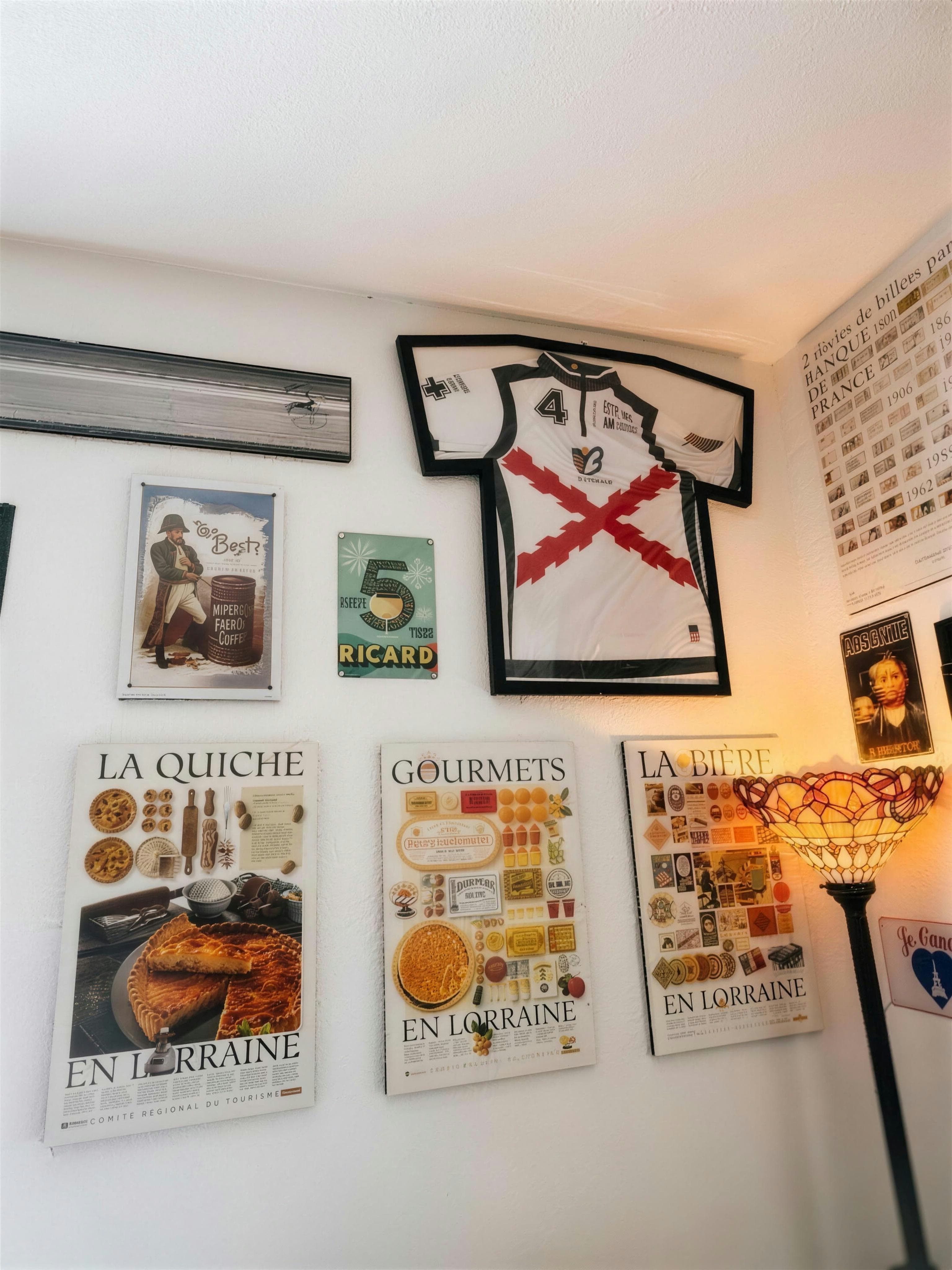 The café wall: a framed polo jersey, vintage Ricard sign and La Quiche & Gourmets en Lorraine posters