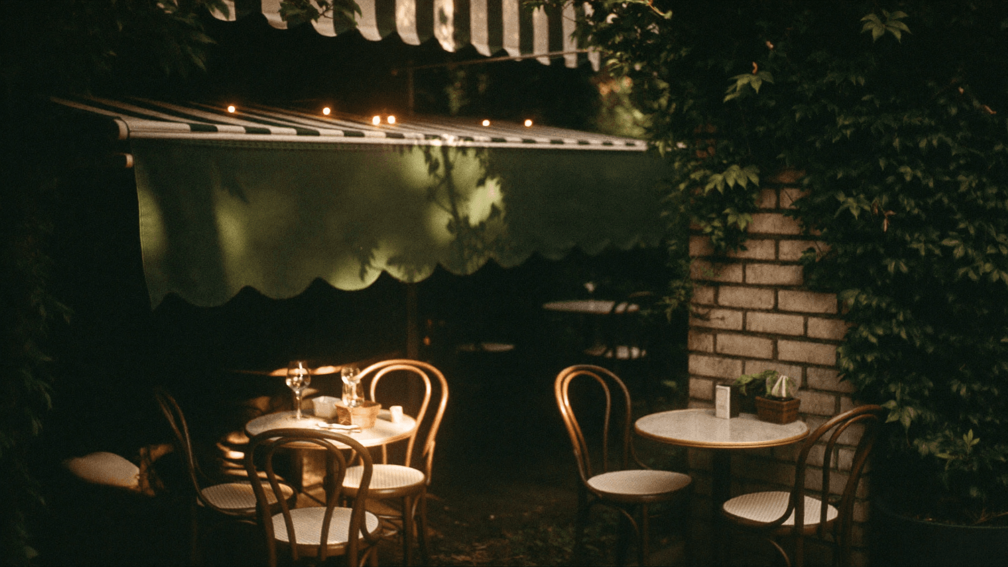 A secluded café garden patio at golden hour with string lights — AI-visualized concept art
